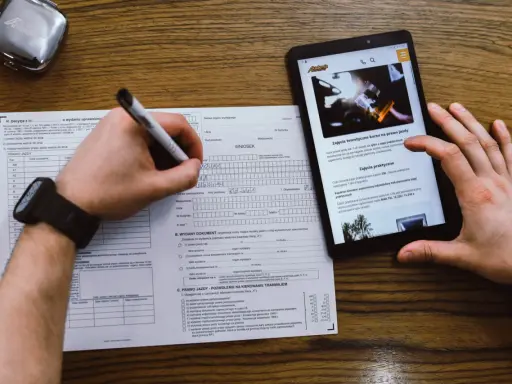 Wniosek o prawo jazdy, kurs na prawo jazdy online. Dokumenty i tablet z informacjami o kursach.