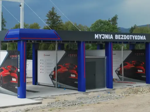 Nowoczesna myjnia bezdotykowa z niebieskimi elementami i reklamami czerwonych samochodów.