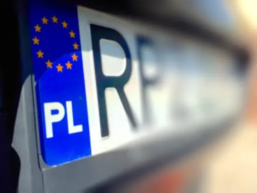Zbliżenie na polską tablicę rejestracyjną z symbolem UE. Czy przy przerejestrowaniu samochodu trzeba oddać tablice?