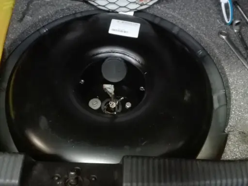 Przygotowania do wymiany butli LPG samemu. Widać narzędzia i pustą butlę w bagażniku.