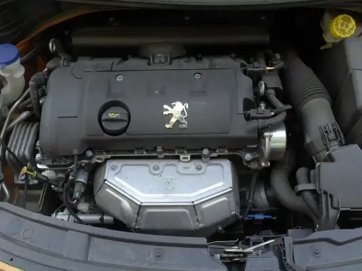 Silnik Peugeota 207. Jaki silnik wybrać? Widok na jednostkę napędową z logo lwa.
