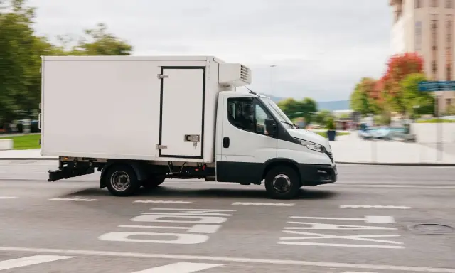 Biała chłodnia na podwoziu Iveco Daily, idealna do transportu towarów wymagających niskiej temperatury. Posiadanie prawa jazdy C1 pozwala na prowadzenie tego typu pojazdu.