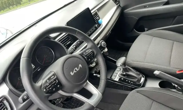 Wnętrze samochodu z automatyczną skrzynią biegów. Widoczna kierownica, deska rozdzielcza i dźwignia zmiany biegów. Idealne do zdobycia prawo jazdy na automat oznaczenie.