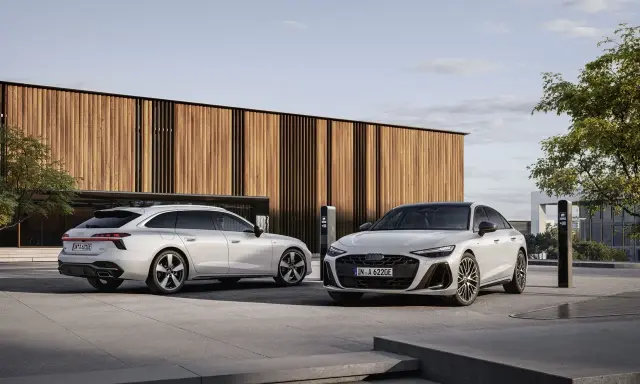 Dwa białe Audi, sedan i Avant, przed nowoczesnym budynkiem. Zastanawiasz się, jakie prawo jazdy na limuzynę?