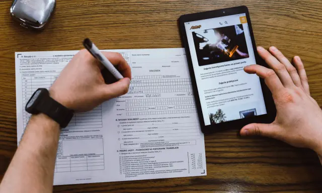 Wniosek o prawo jazdy, kurs na prawo jazdy online. Dokumenty i tablet z informacjami o kursach.