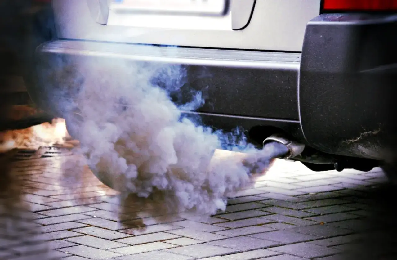 Gęsty, biały dym wydobywa się z rury wydechowej samochodu. To jeden z objawów złej jakości paliwa diesel.