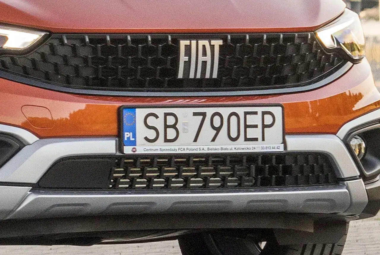 Pomarańczowy Fiat z tablicą rejestracyjną SB 790EP.