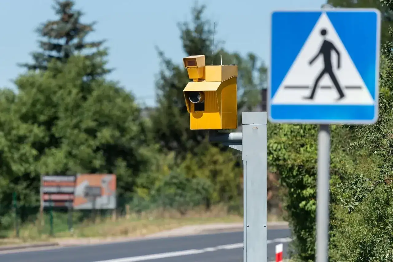 Żółta skrzynka fotoradaru przy przejściu dla pieszych. Uważaj, bo przekroczenie prędkości o 30 w terenie zabudowanym grozi mandatem.