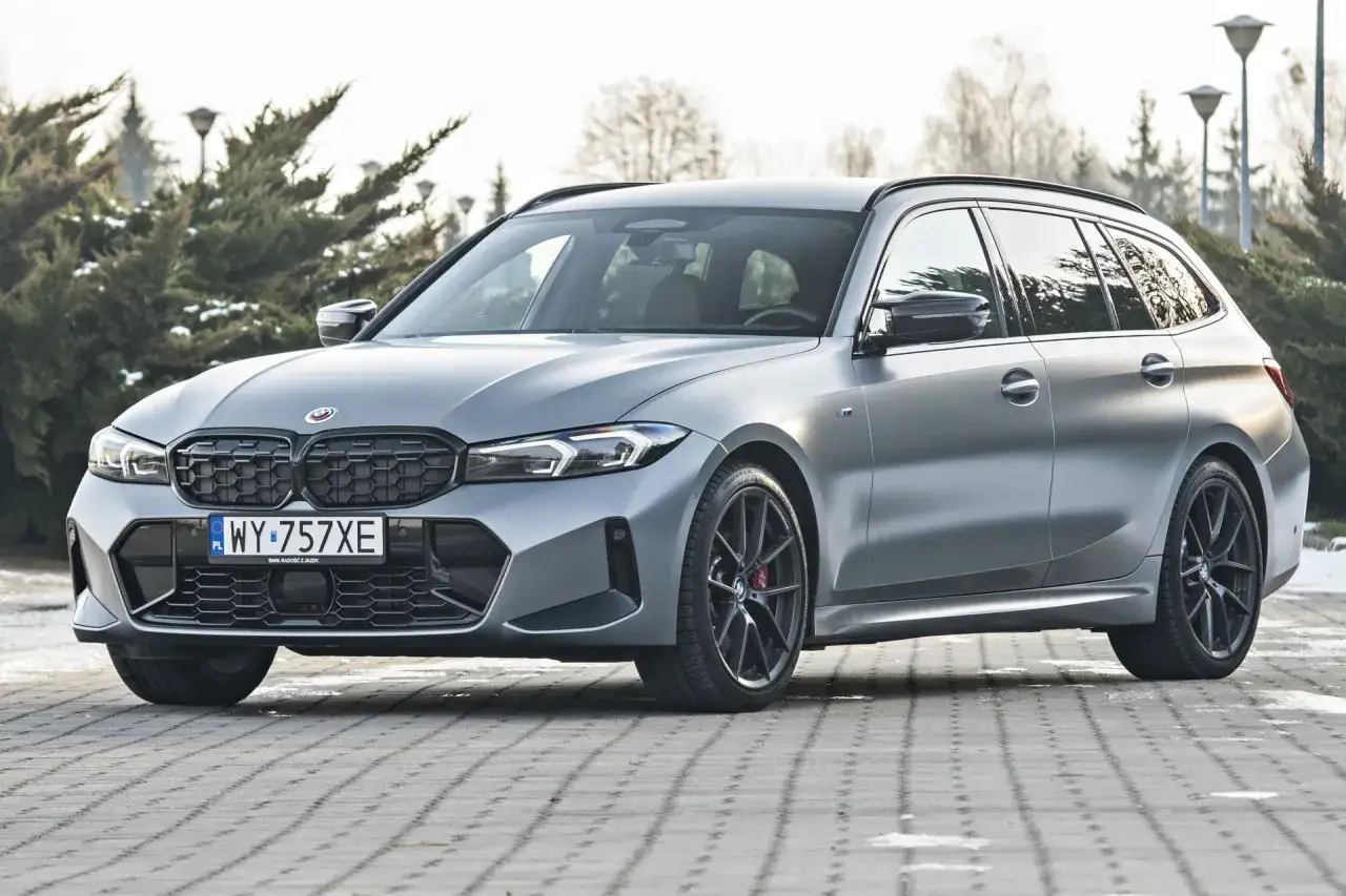 Szary kombi klasy d BMW z czarnymi felgami i czerwonymi zaciskami hamulcowymi.