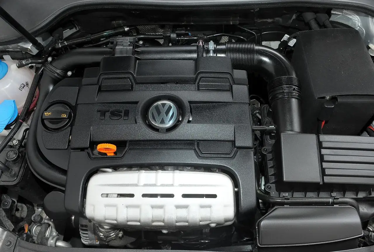 Silnik TSI w Golfie 6. Widok na pokrywę silnika z logo VW i oznaczeniem TSI.