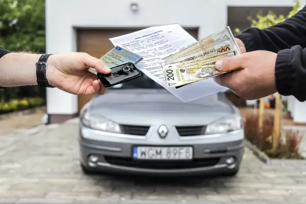 Transakcja kupna auta na dowód osobisty: dokumenty, kluczyki i pieniądze w rękach.